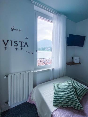 a bedroom with a window and a bed with a pillow at Locanda alla Grotta in Crone