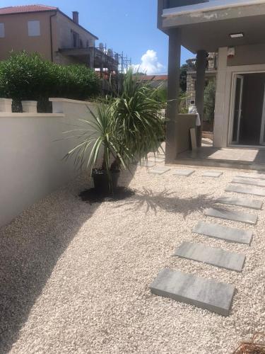 a garden with a stone pathway and a house at Daphne Luxe Retreat -Sea View-King size bed- in Supetar