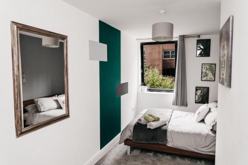 a bedroom with a mirror and a bed and a window at Modern Centre of the city 1 bedroom apartment in Sheffield