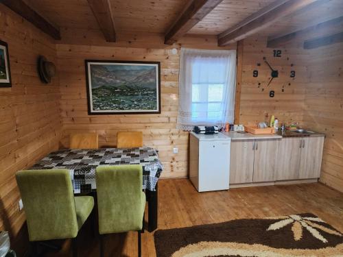a dining room with a table and a kitchen at Planinska tišina Guest House in Pluzine