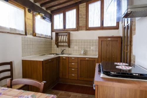 een keuken met houten kasten, een wastafel en ramen bij Agriturismo Pontignanello in Siena