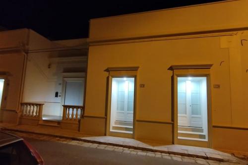 three doors on the side of a building at night at Dimora Collina 2 in Sannicola