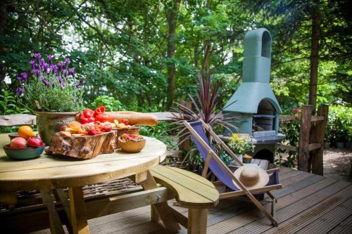 a table with fruits and vegetables on a deck at HAYNE BARN ESTATE ECOLODGES in Hythe