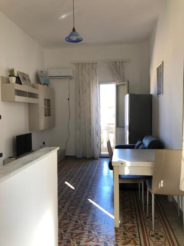 una cucina e un soggiorno con tavolo e frigorifero di Montefusco a Crotone