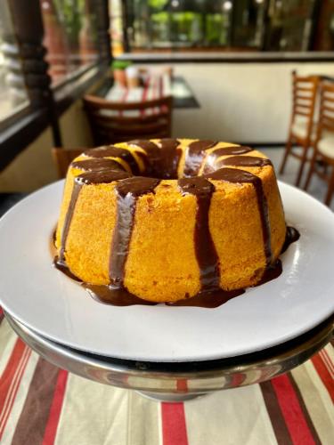 um bolo de chocolate em um prato sobre uma mesa em Pousada Pérola do Porto em Porto de Galinhas