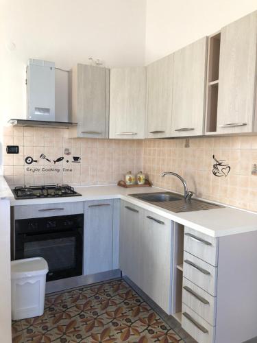 a kitchen with white cabinets and a sink at Montefusco in Crotone