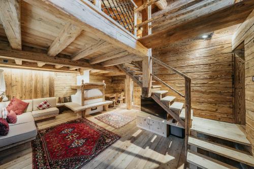 a living room with wooden walls and wooden stairs at Luxury Cortina in Cortina dʼAmpezzo