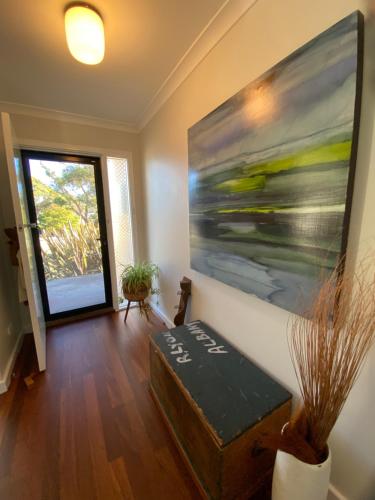 a living room with a painting on the wall at Nelson Cottage - relaxed retro, modern and original in Albany
