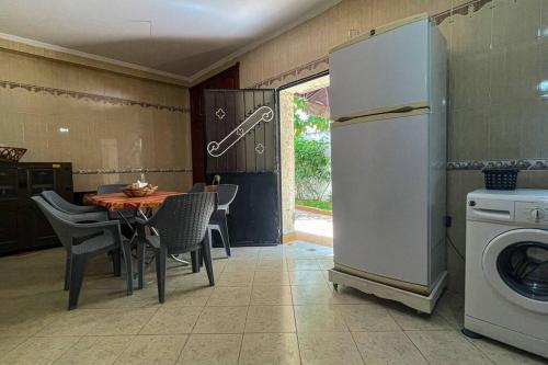 a kitchen with a table and a white refrigerator at Villa tranquility in Tangier