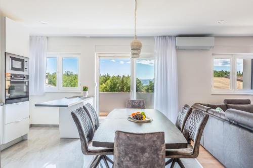 a kitchen and living room with a table and chairs at Apartmani Ksenija in Omiš