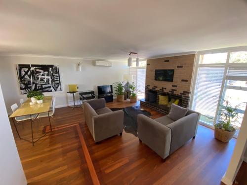 a living room with a couch and a table at Nelson Cottage - relaxed retro, modern and original in Albany