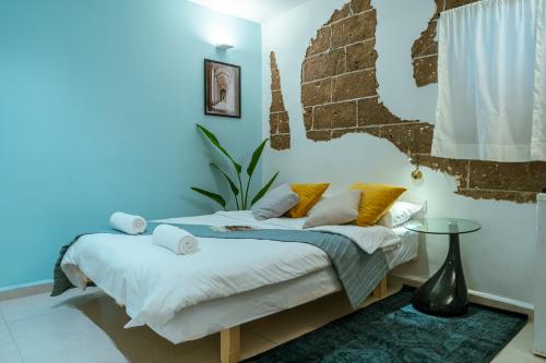 a bedroom with a bed with a blue wall at Jabitat- Jaffa Boutique TLV in Tel Aviv
