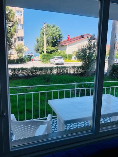 Blick aus einem Fenster auf eine Terrasse mit einem Tisch in der Unterkunft Sea View Modern Appartement with a Privet Garden in Çiftlikköy