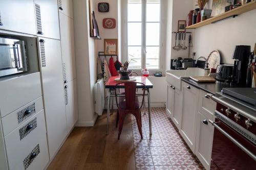 une cuisine avec une petite table au milieu dans l'établissement Haussmanien, à Angers