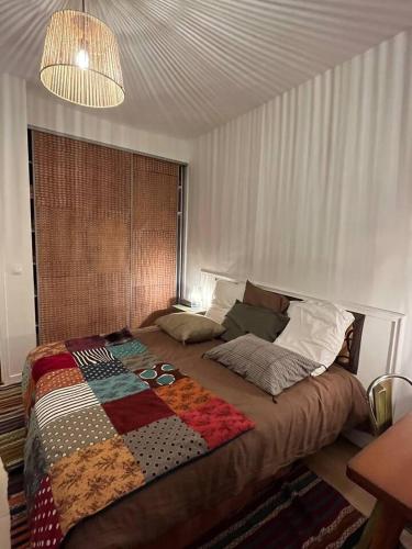 un lit avec une couette dessus dans une chambre dans l'établissement Haussmanien, à Angers