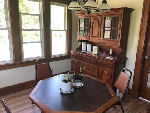 a dining room with a table and a wooden cabinet at Seabreeze Three Bedroom Home in Rochester