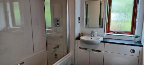 a white bathroom with a sink and a shower at Blairgowrie Holiday Park in Blairgowrie