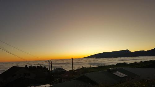 a view of the sun rising over a layer of clouds at Case Vi d' o' in Le Tampon