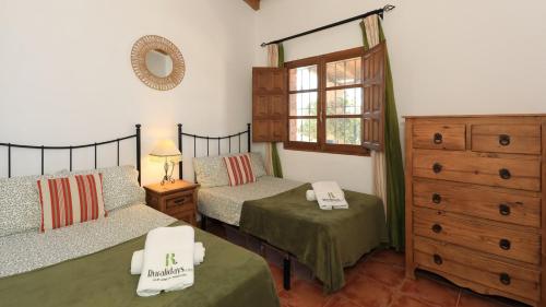 una camera con due letti, un comò e una finestra di La PacAna Álora by Ruralidays ad Alora