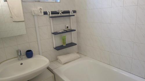 baño blanco con lavabo, bañera y aseo en Villa Sümeg en Sümeg