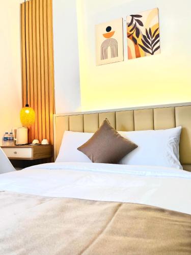 a bedroom with a large bed with white sheets at Torino Hotel Dalat in Da Lat