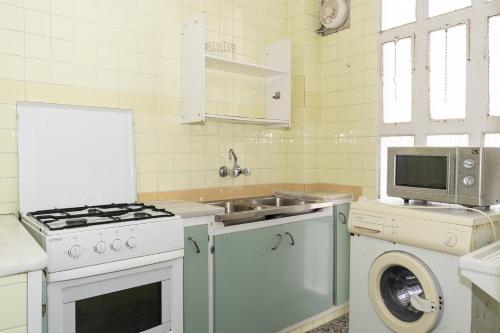 a kitchen with a stove and a sink and a washing machine at Provence, 5º-17 in Cullera