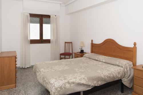 a bedroom with a bed and a chair and a window at Provence, 5º-17 in Cullera