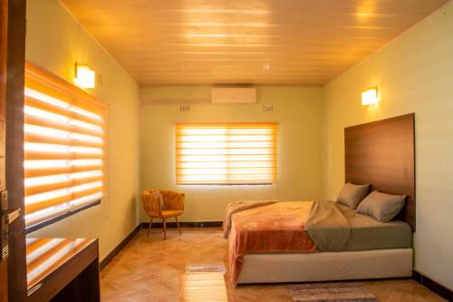 a bedroom with a bed and a window at Hillview Elegant Residential Suites in Chilenje