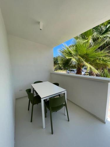a white room with a table and chairs and a window at Sant'Elia Deluxe Rooms in Vieste