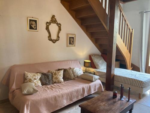 a living room with a couch and a bed at Les Fontaines du Mas des Fontaines in Montagnac