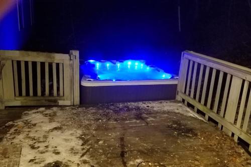a jacuzzi tub with blue lights next to a fence at Catskill Mountain Retreat in West Kill