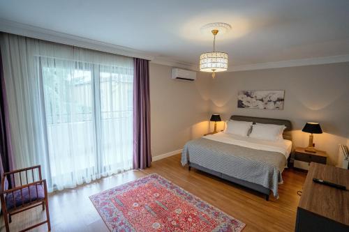 um quarto com uma cama e uma grande janela em Verula City Apartments em Trebizonda