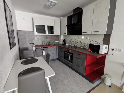 a kitchen with white cabinets and a red counter top at Neue Bungalow Ferienwohnung in Ansbach
