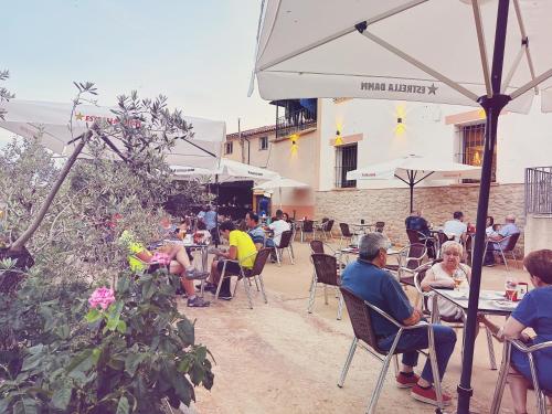 un grupo de personas sentadas en mesas en un restaurante al aire libre en Fonda Aparicio, en Fuentespalda