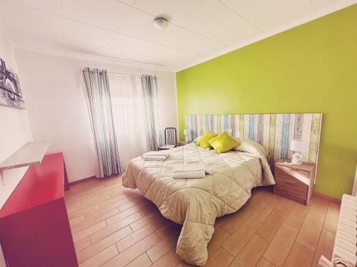 a bedroom with a large bed with green walls at Fonda Aparicio in Fuentespalda
