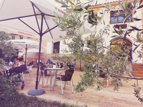 a restaurant with tables and chairs and an umbrella at Fonda Aparicio in Fuentespalda