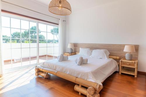 een slaapkamer met een groot bed en een groot raam bij Villa Aurea in Carvalhal