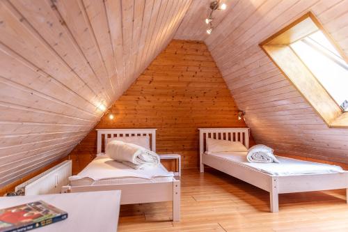 two beds in a room with a wooden ceiling at Ferienwohnung 50008 in Carolinensiel