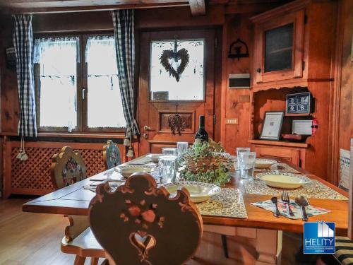un comedor con una mesa con un corazón en las ventanas en Dolomites Stunning View & Garden en San Vito di Cadore