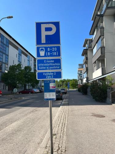 una señal de estacionamiento al lado de una calle en Studio by Sello shopping mall en Espoo