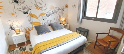 a bedroom with a bed with a flower mural on the wall at Le Relais des 4 Saisons - Chambres d'hôtes B&B en Baie de Somme in Saint-Valery-sur-Somme