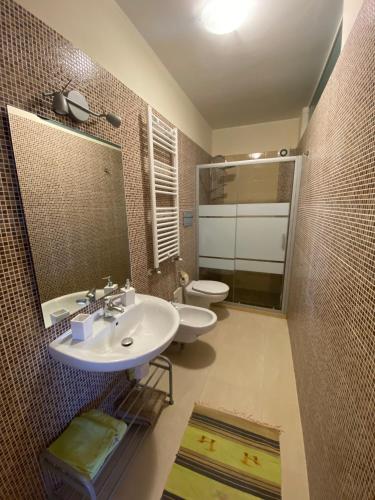 bagno con 2 lavandini, servizi igienici e specchio di Villanna a Sperlonga