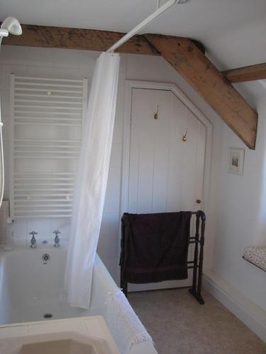 a bathroom with a bath tub and a window at The Old Farmhouse in Crackington Haven