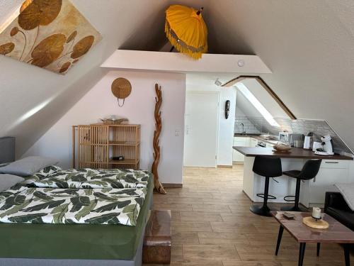 ein Schlafzimmer mit einem Bett und einem Tisch sowie eine Küche in der Unterkunft Appartement Bali in Hüllhorst