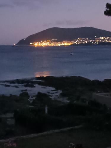 una vista del océano por la noche con una ciudad en Casiña Palmira, en Finisterre