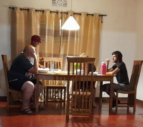 Un groupe de personnes assises autour d'une table dans l'établissement ArushaLand homestay, à Arusha