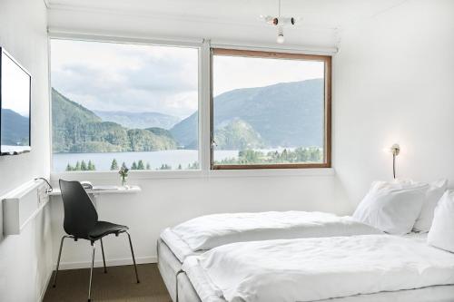 a bedroom with a bed and a large window at Energihotellet in Nesflaten
