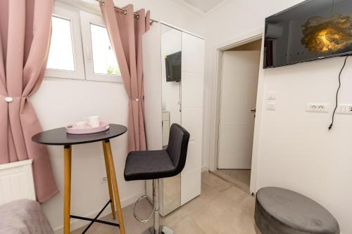 um quarto com uma mesa, uma cadeira e uma televisão em Luxury rooms Erceg em Zadar