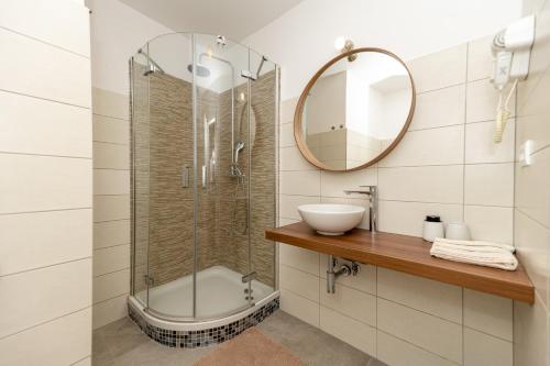 uma casa de banho com um chuveiro, um lavatório e um espelho. em Luxury rooms Erceg em Zadar