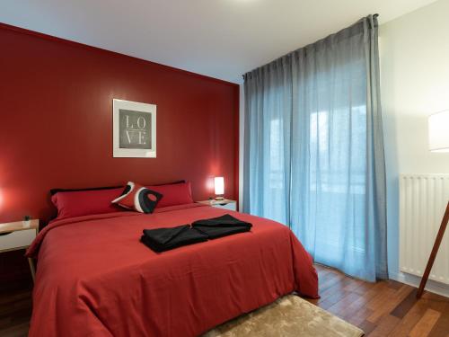 - une chambre rouge avec un lit avec un mur rouge dans l'établissement LE PHENIX - HYPERCENTRE 16 PERSONNES GARAGE GRATUIT WiFi JARDIN BARBECUE PROCHE PARC TETE D'OR, à Villeurbanne
